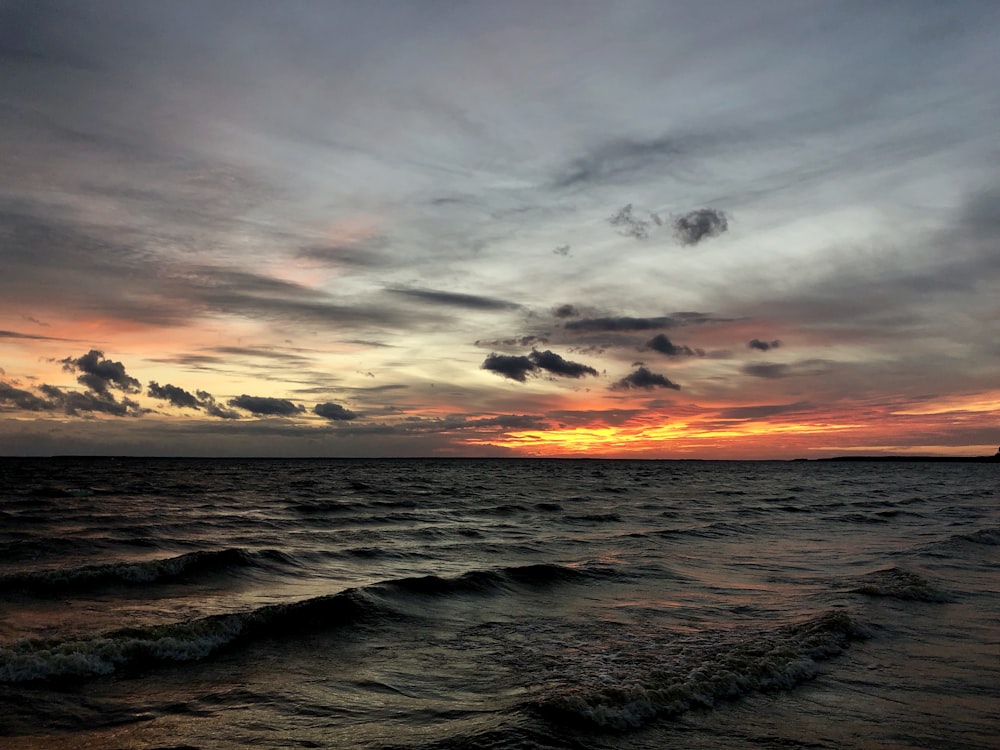 nature photography of sea waves under cloudy sky during golden hour