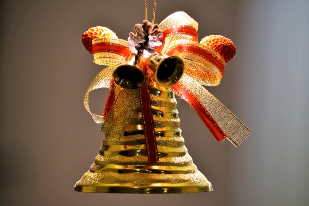 selective focus photo of gold and red bell ornament