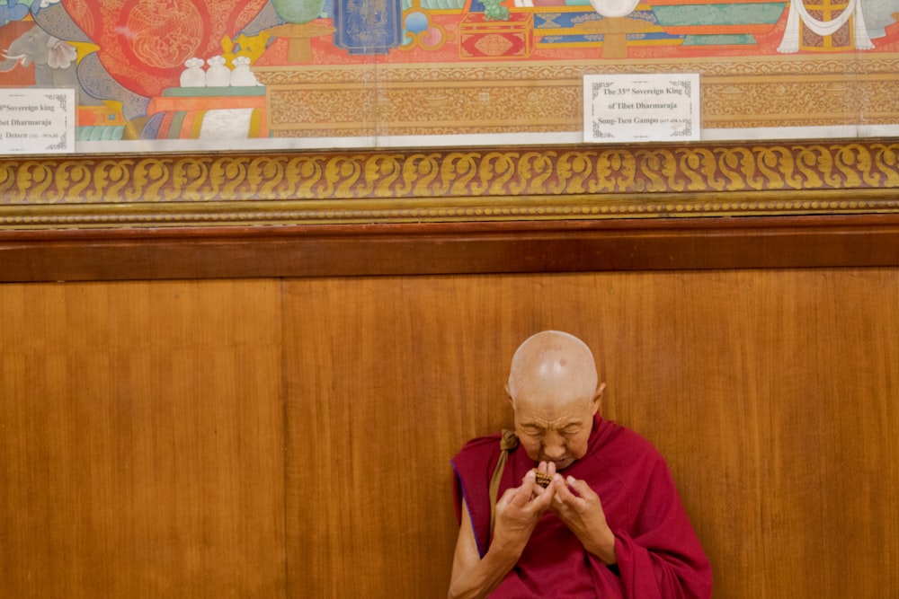 monk leaning on wall