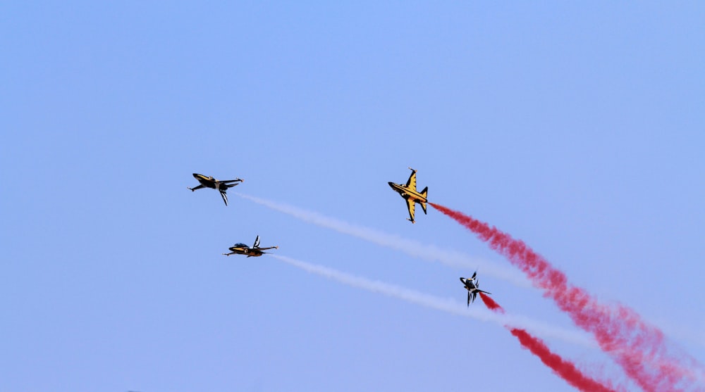 four jet fighters at mid air during daytime