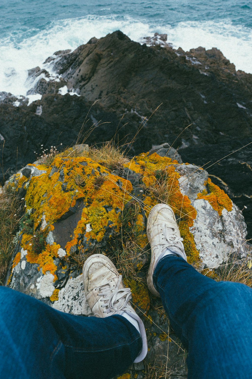 Person, die tagsüber auf einem Felsen sitzt