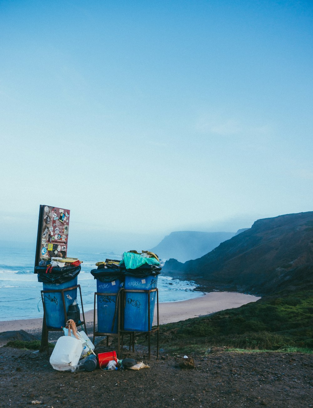3 bidoni della spazzatura blu in spiaggia