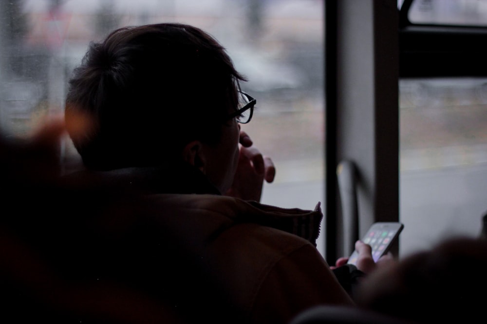 man holding phone sitting on chair