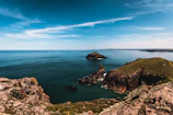 A panoramic view of São Jorge island's lush green cliffs under a bright blue sky.