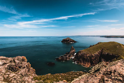A panoramic view of São Jorge island's lush green cliffs under a bright blue sky.