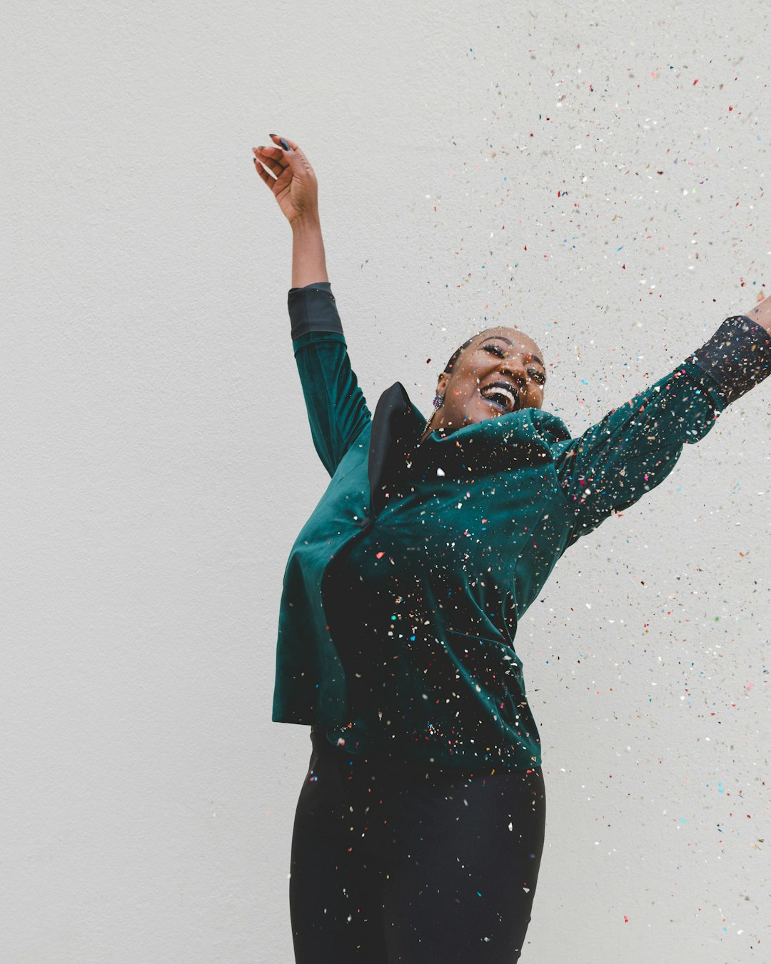 woman jumping in confetti with a huge smile on her face