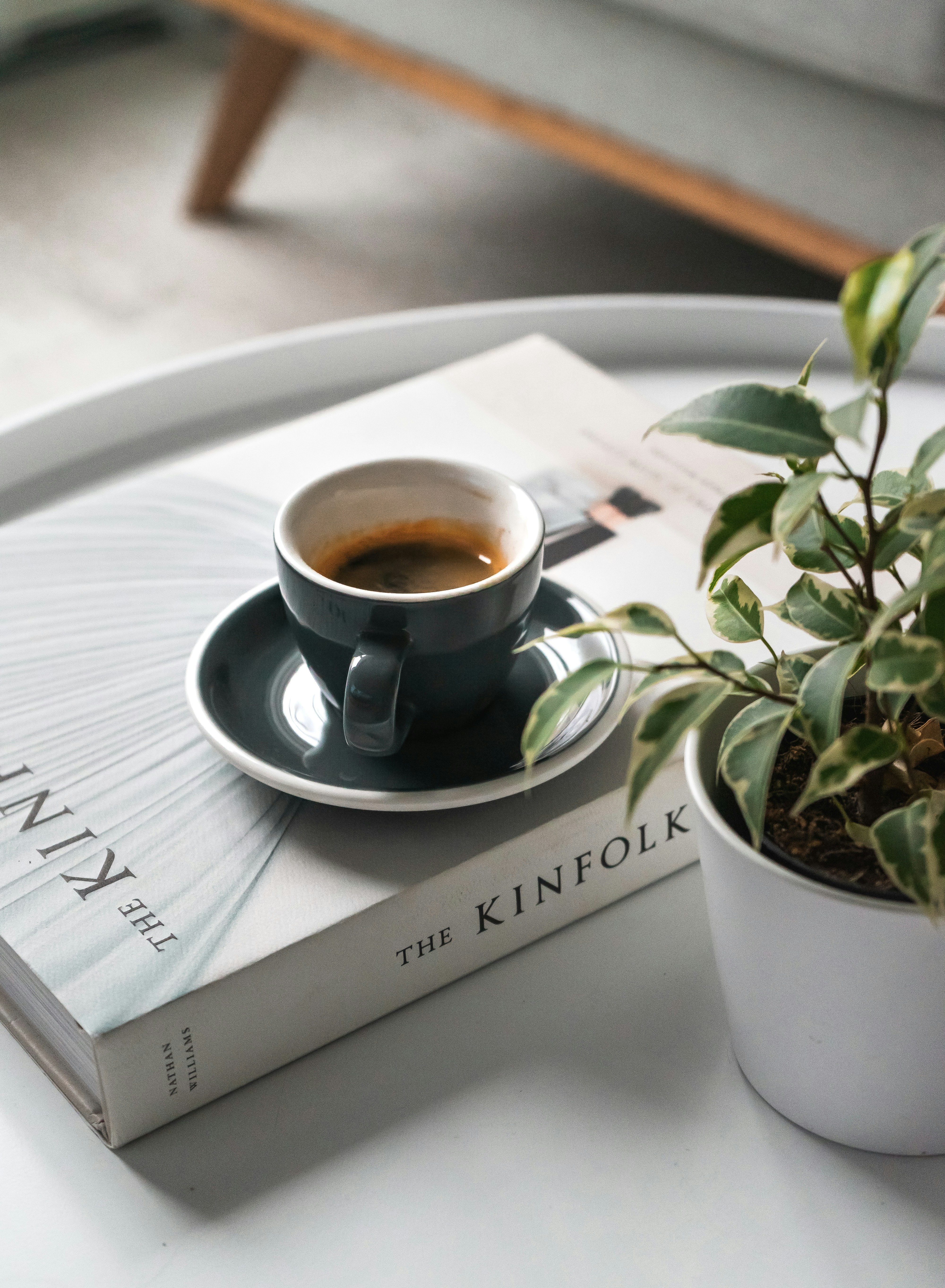 shallow focus photo of black ceramic mug and saucer on white book