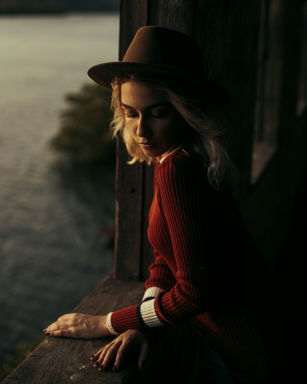 woman wearing brown hat across body of water