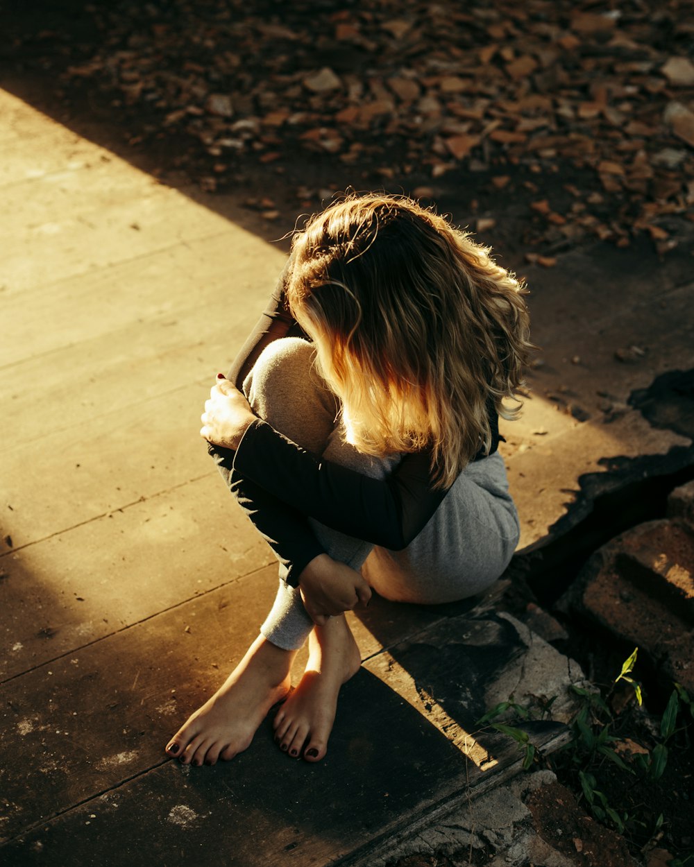 woman sitting on brown wooden surface