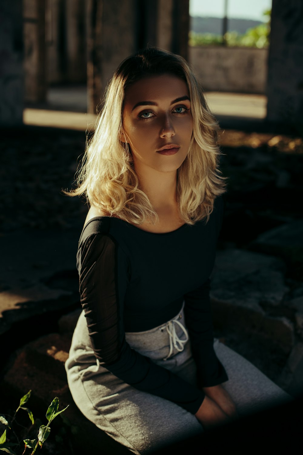 blonde woman in black scoop neck long sleeved shirt and grey pants