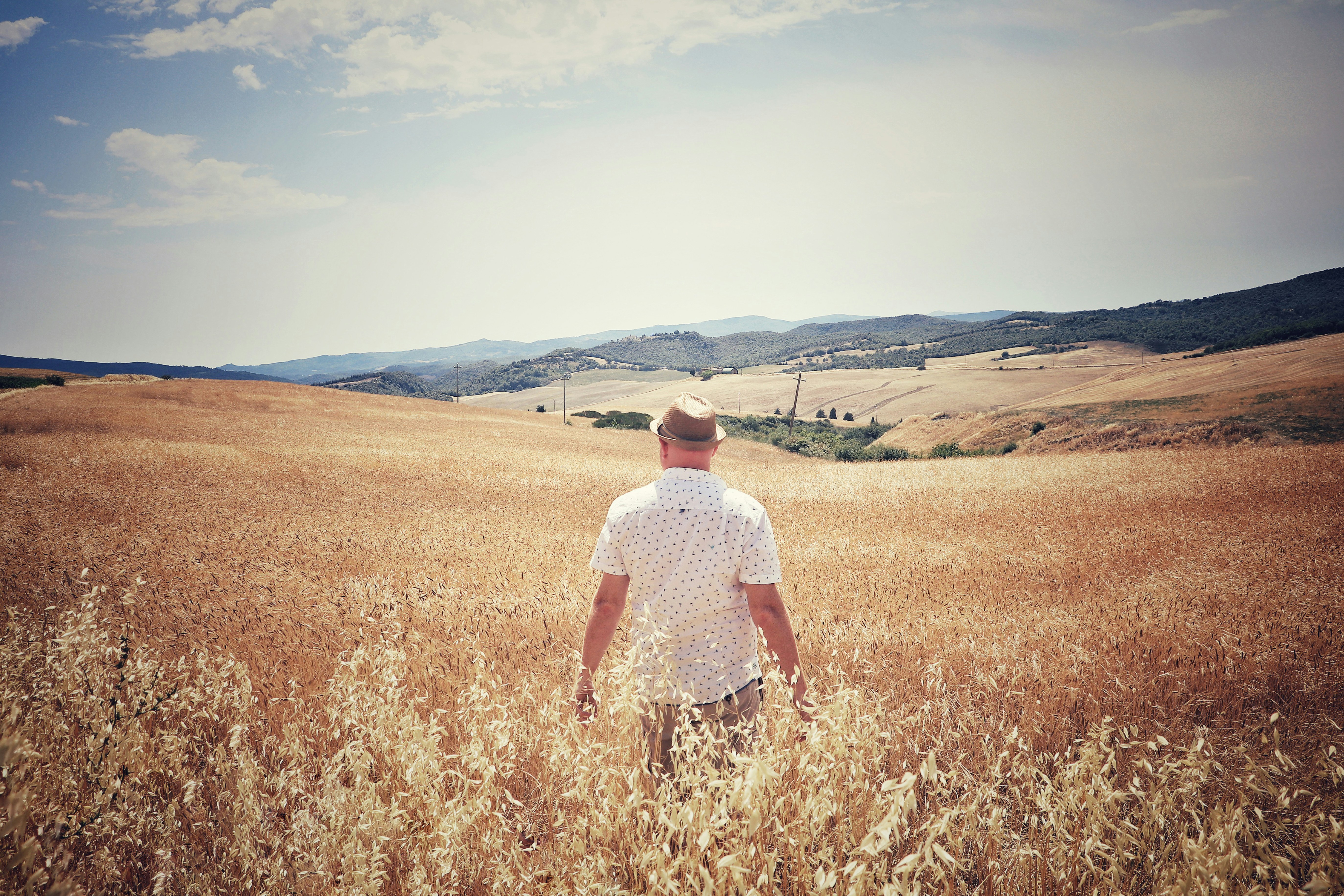 man standing between brown field