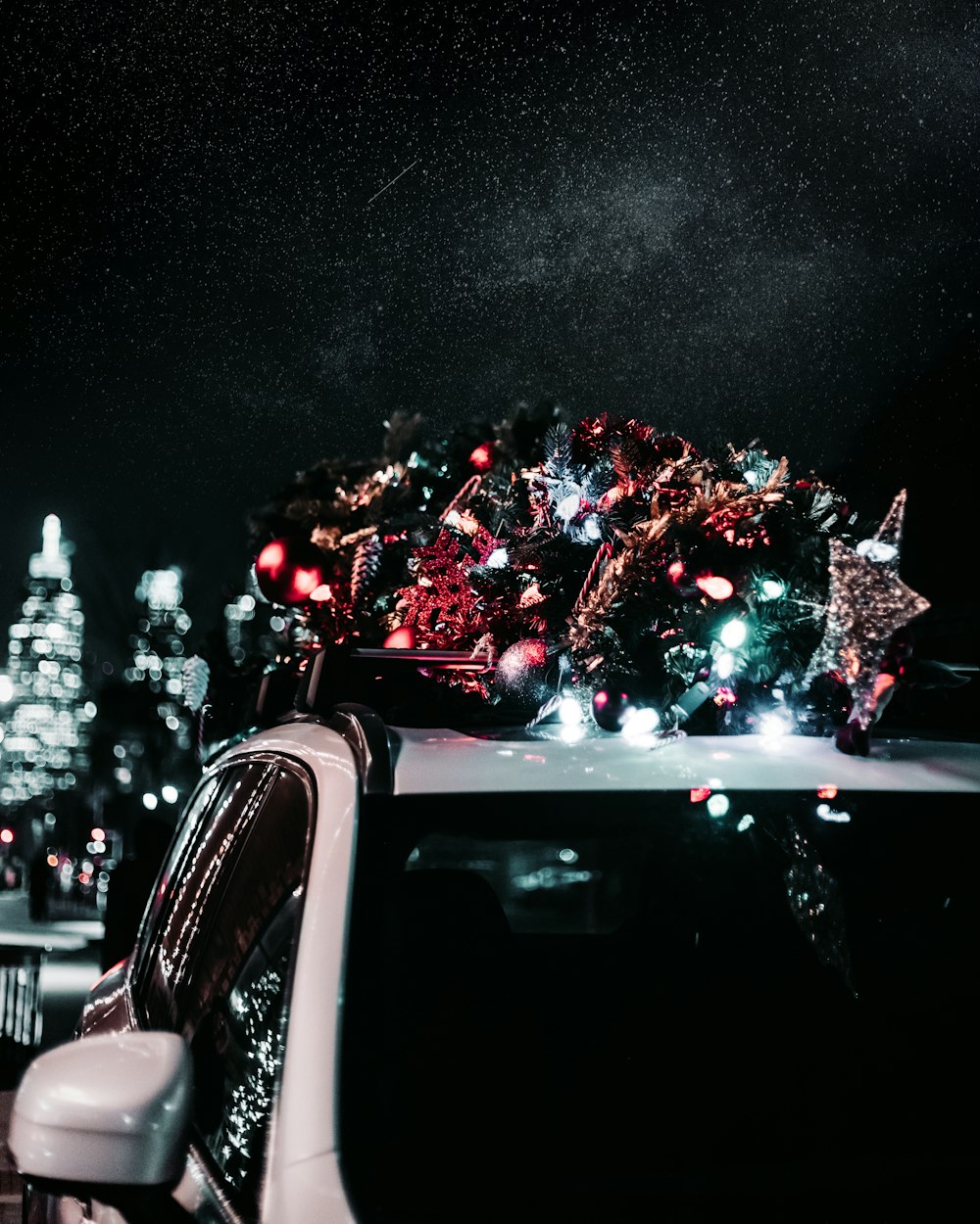 white vehicle carrying Christmas tree