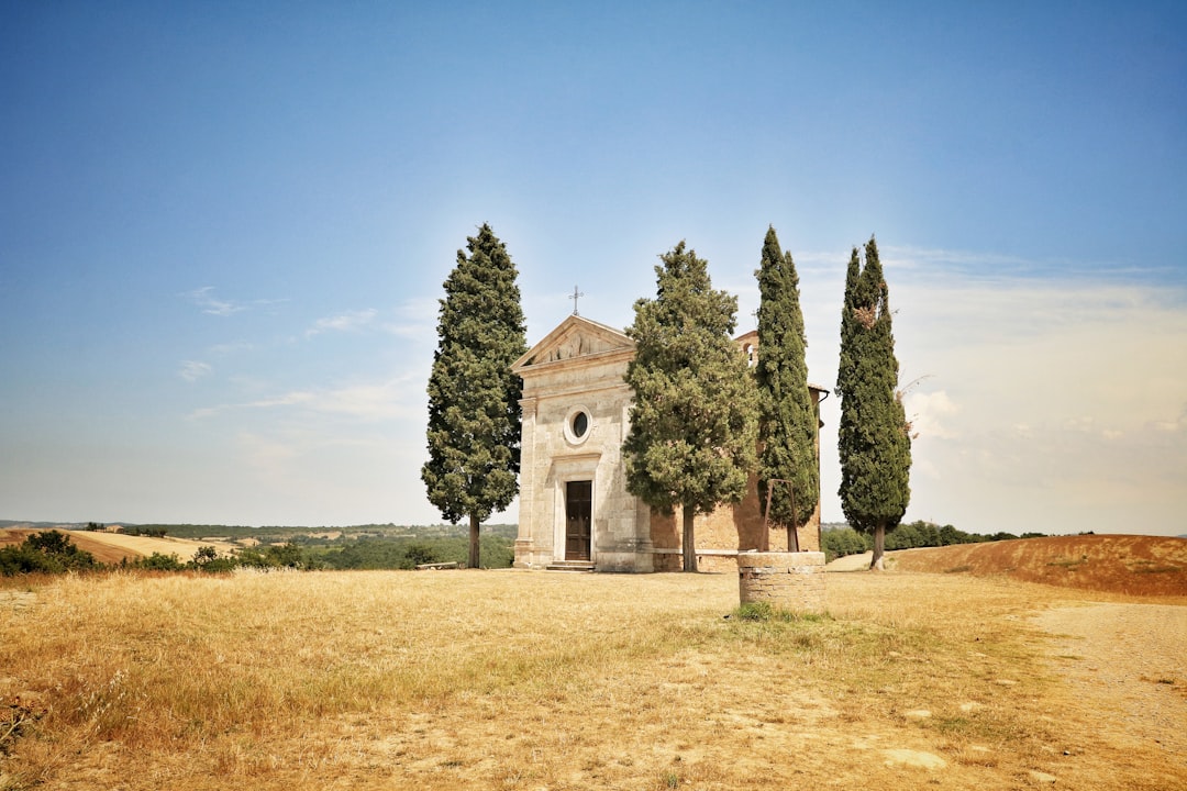 white concrete building between green trees, Nestled amidst the picturesque landscapes of San Quirico d