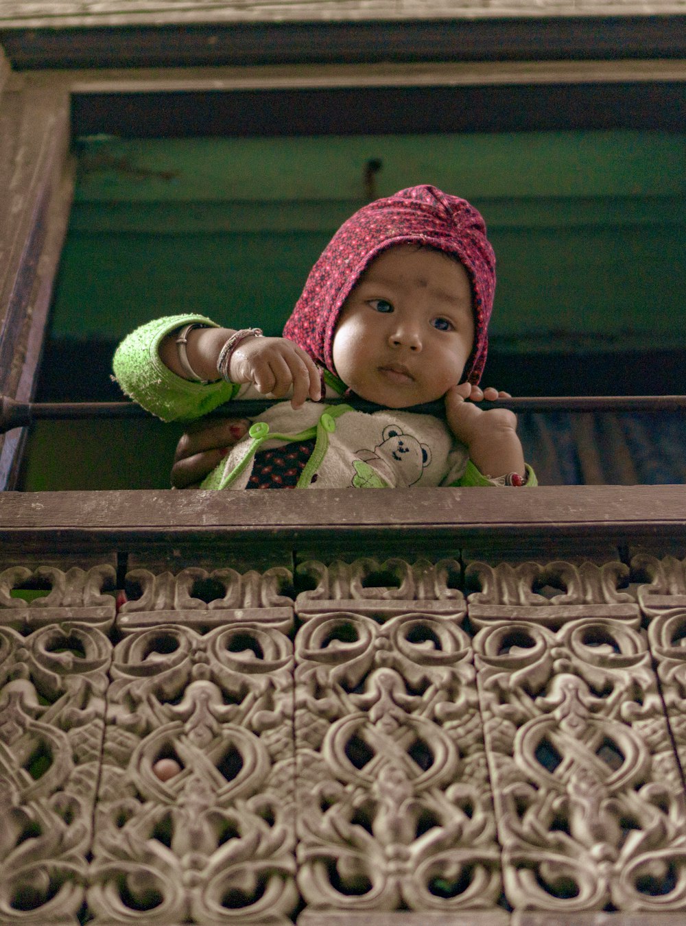 toddler holding on brown metal rail