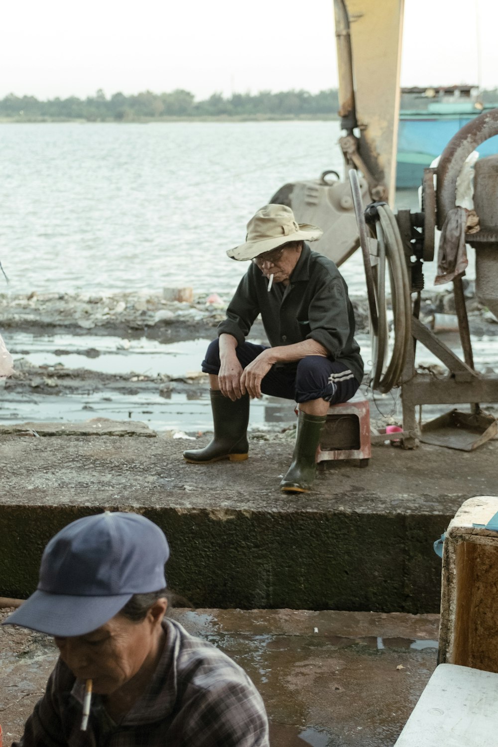 man sitting down beside body of water