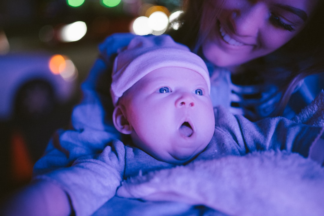 selective focus photography of woman holding baby