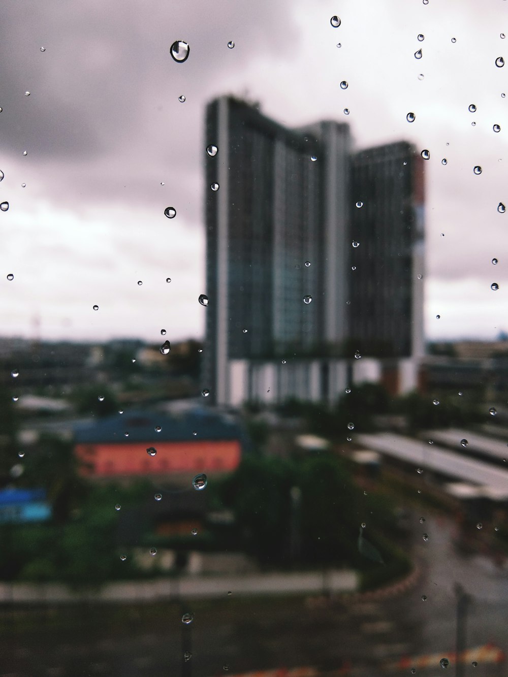 a view of a building through a rain soaked window