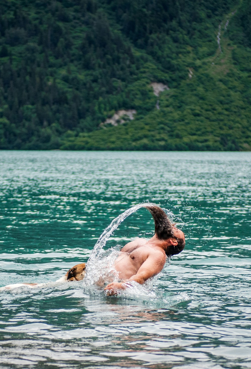 man bathing on body of water