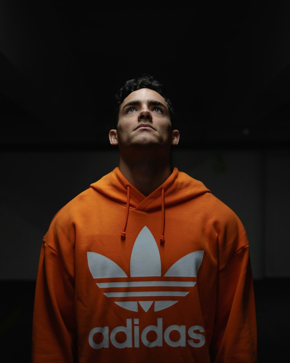 man wearing orange adidas pullover hoodie