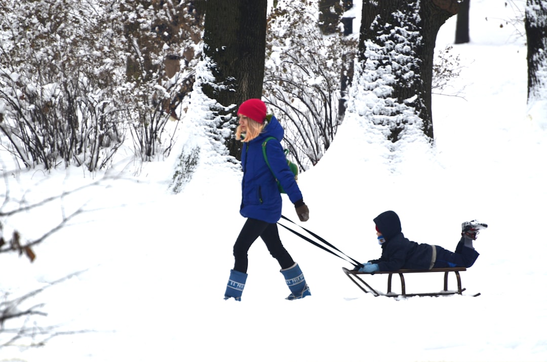 Mom with child on sleigh in winter park