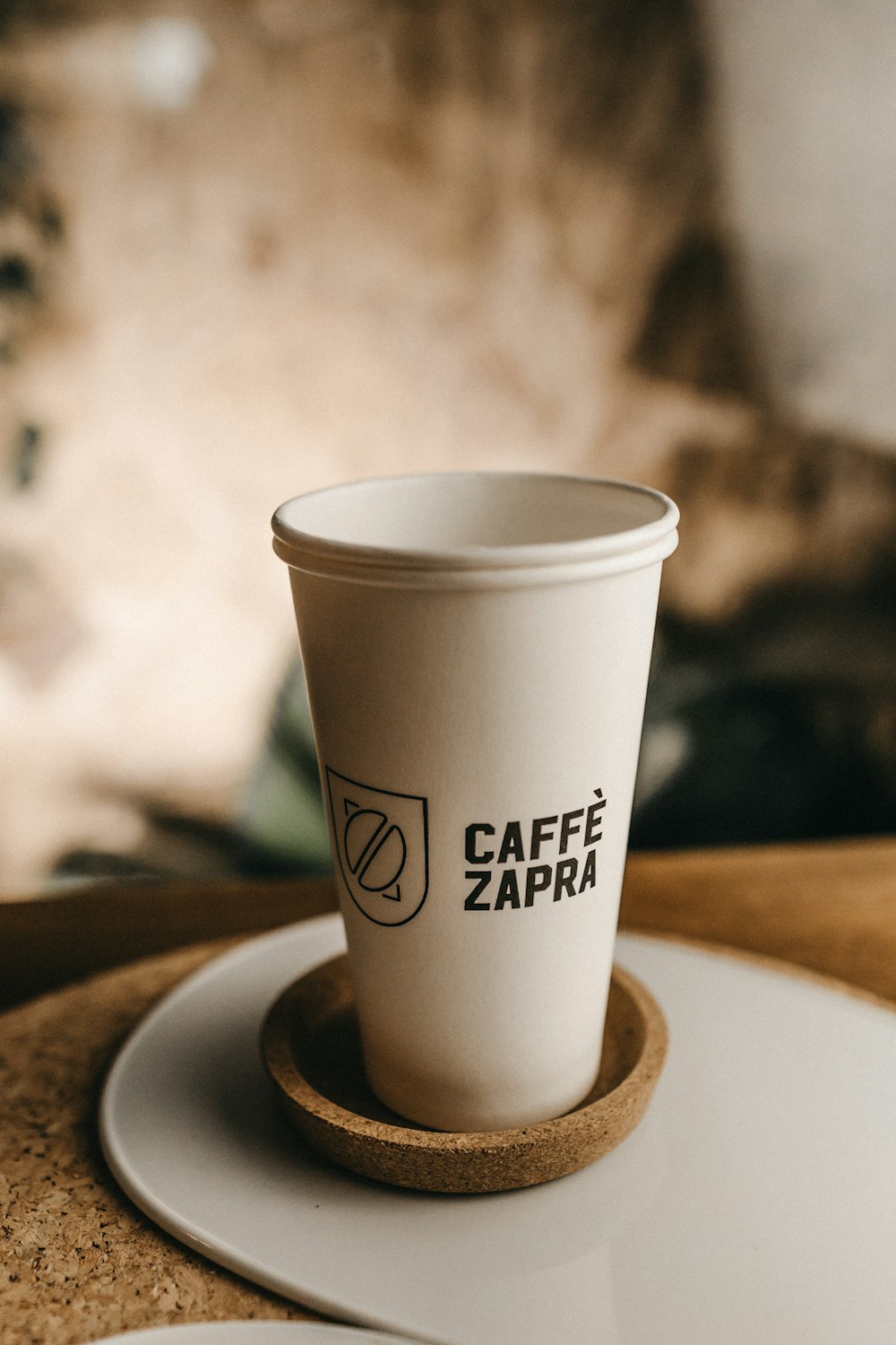 white and black Caffe Zapra cup on table