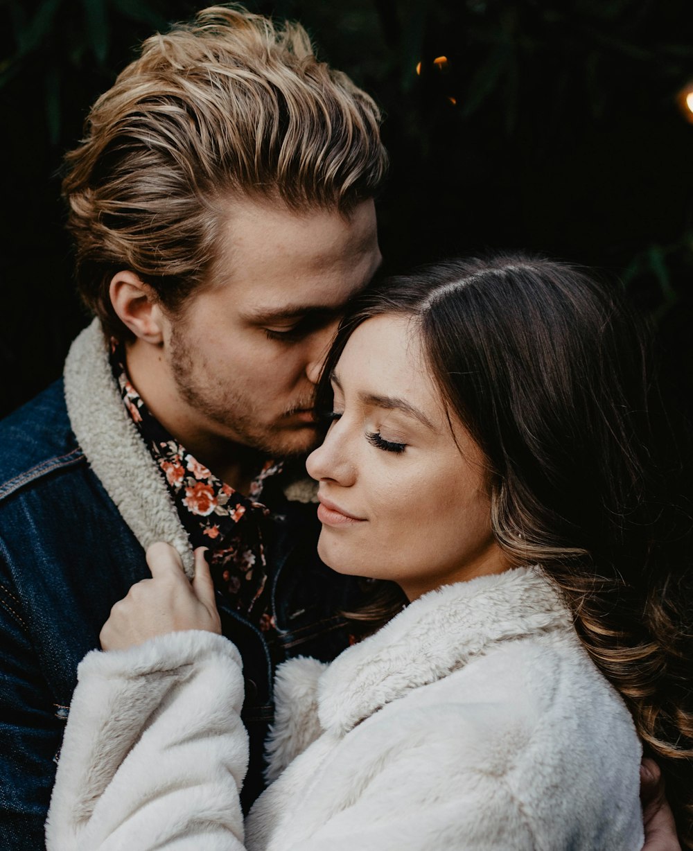 shallow focus photo of man kissing woman