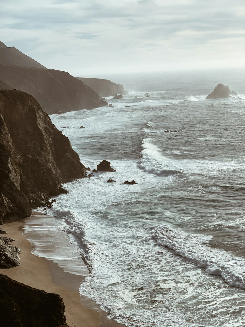 ocean wave beside rock formation