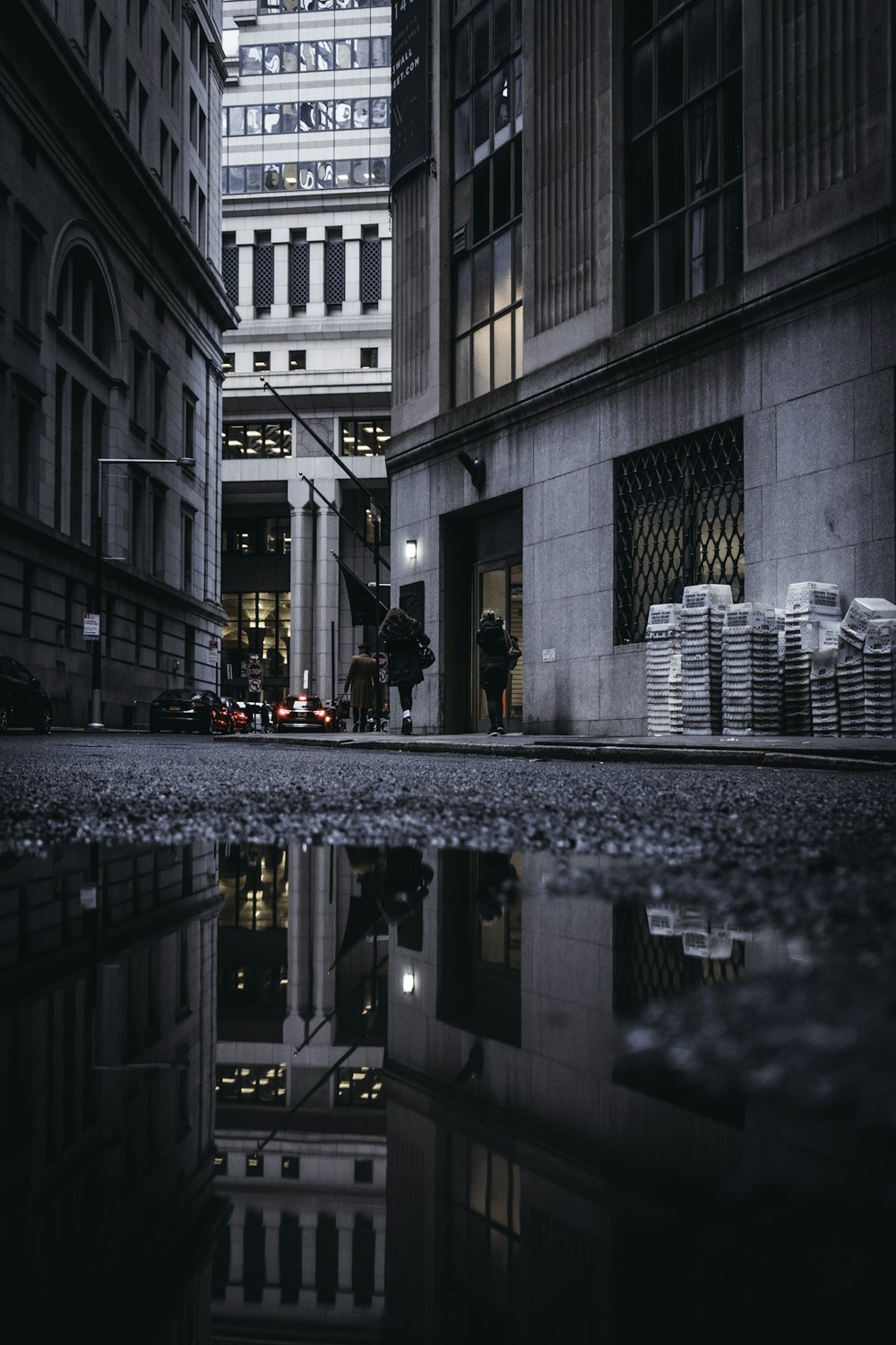 grayscale photography of person walking near building