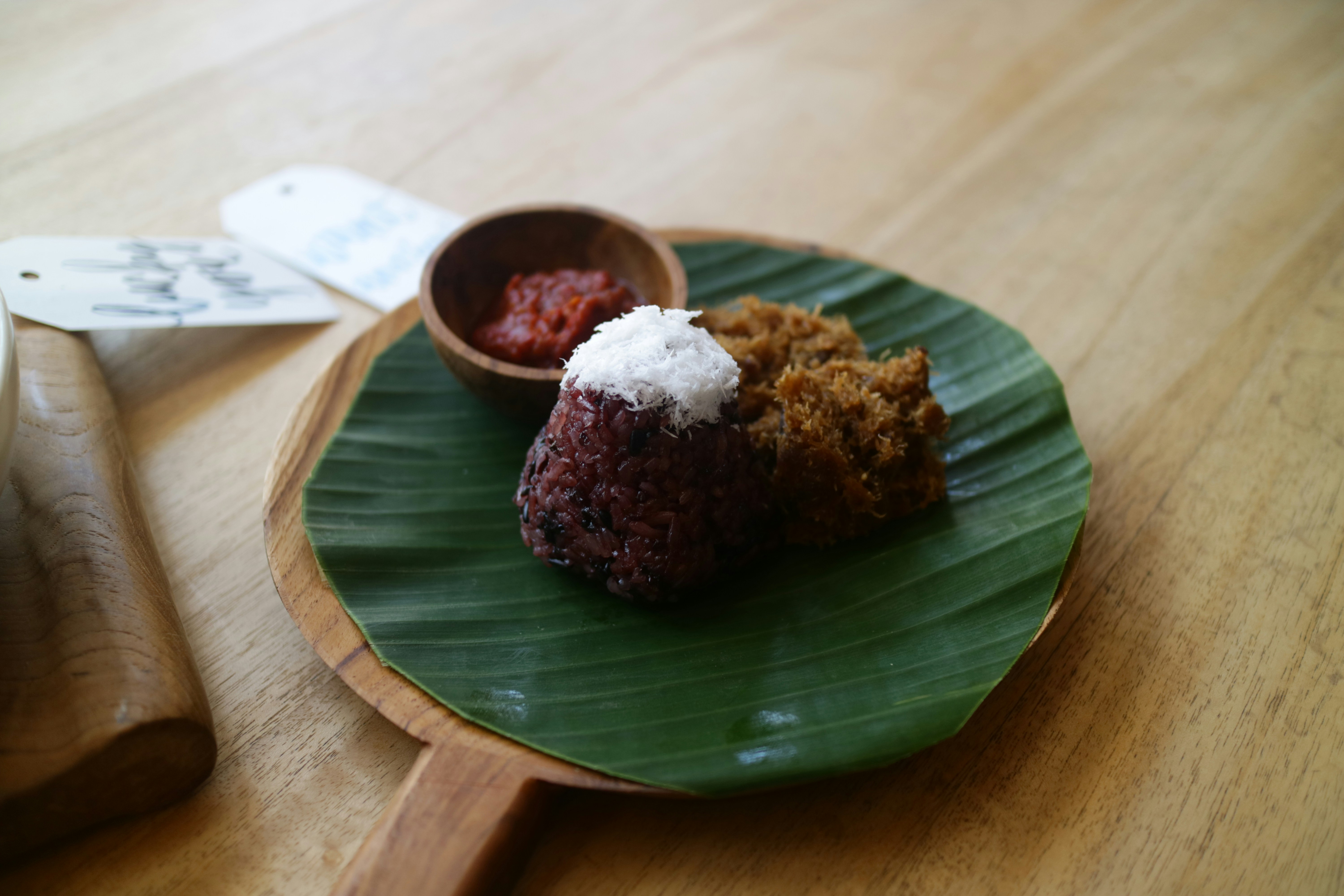 Two pieces of freshly baked bibingka rice cake with salted egg and coconut on banana leaf