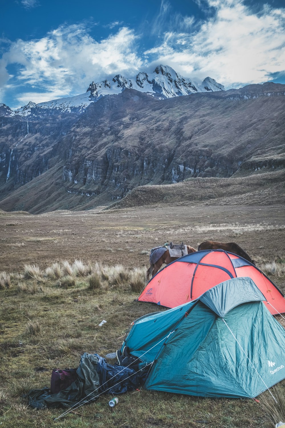 산에 두 개의 파란색과 빨간색 캠핑 텐트