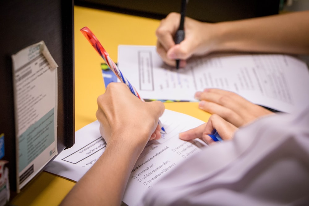 person writing on white paper