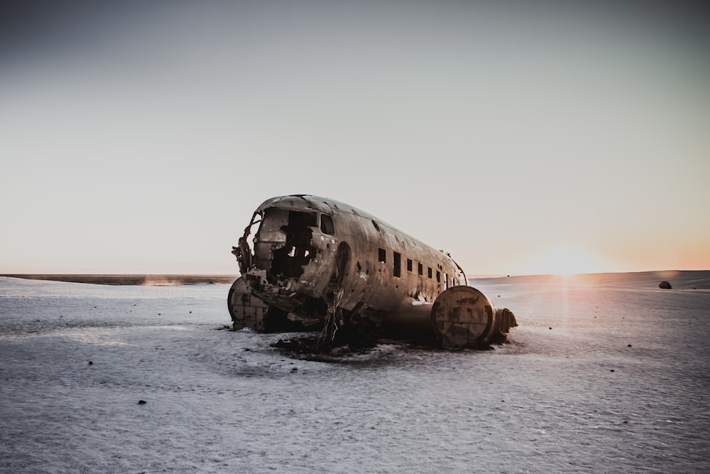 grey airplane wreckage on grey desert land