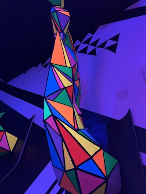 A bold and luminous geometric pattern in vivid neon colors on black.