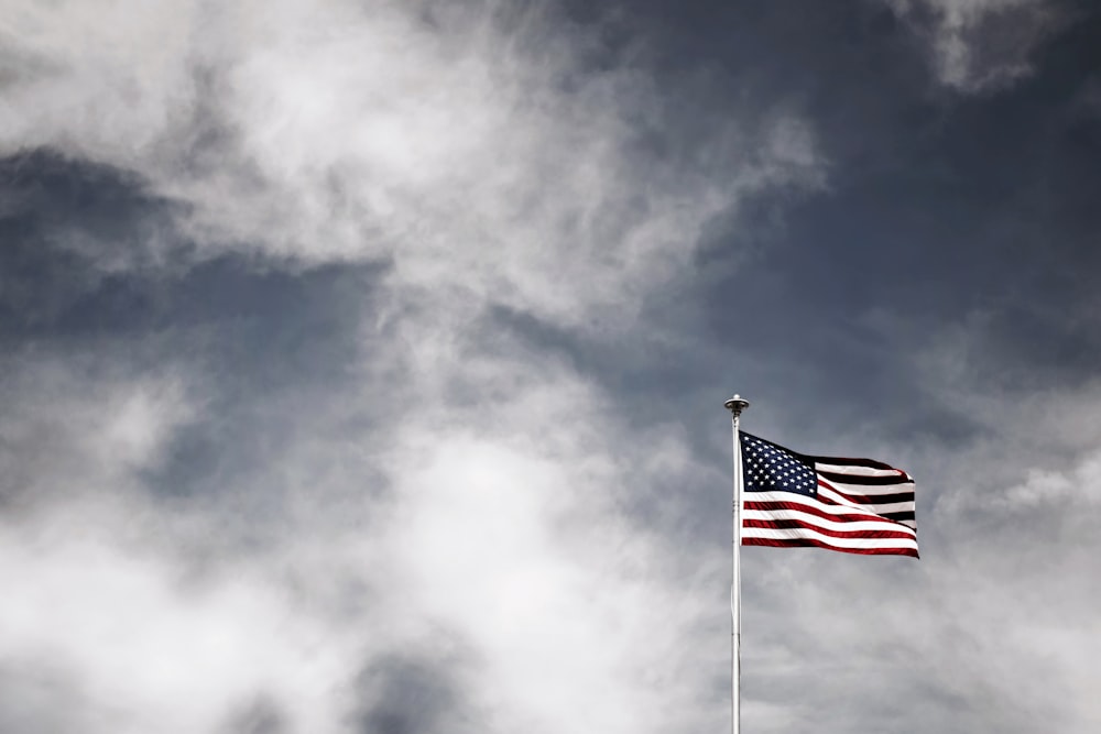 waving USA flag under grey sky