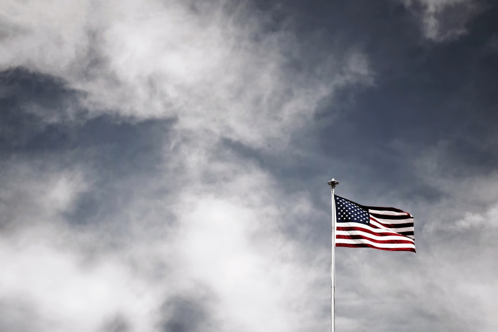 acenando bandeira dos EUA sob o céu cinzento