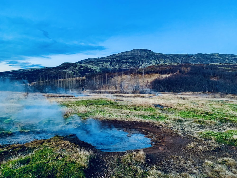 body of water in front of mountain under blue sky