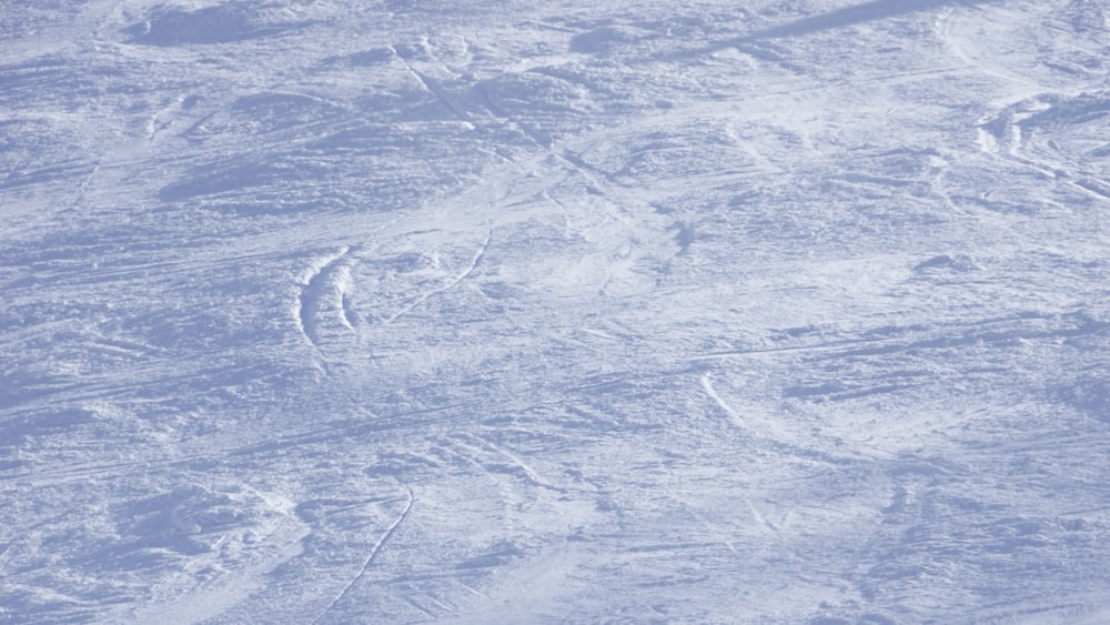 a man riding a snowboard down the side of a snow covered slope