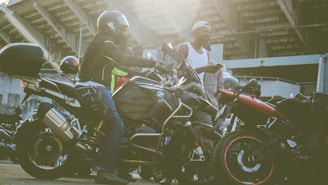 A group of diverse volunteers gathered around motorcycles, discussing safety gear and strategies.