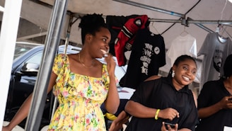 Happy customers browsing through colorful women's fashion items at a 99koutlet pop-up event.