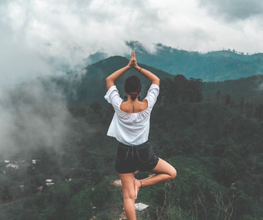 woman standing on rock facing forest