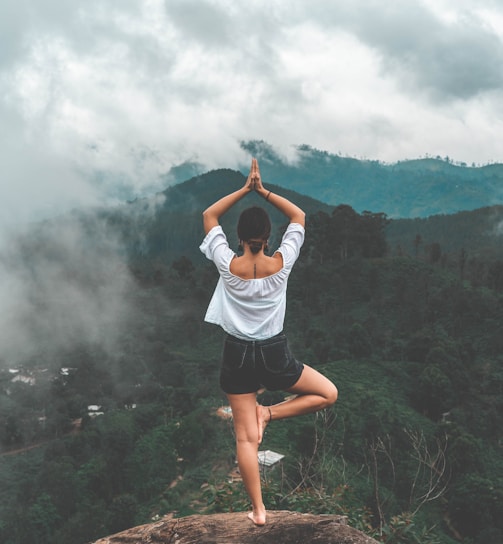 woman standing on rock facing forest