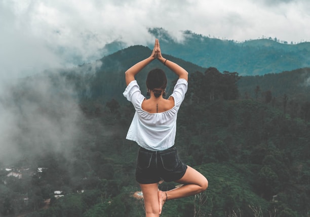 woman standing on rock facing forest