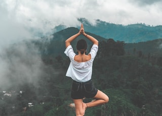 woman standing on rock facing forest