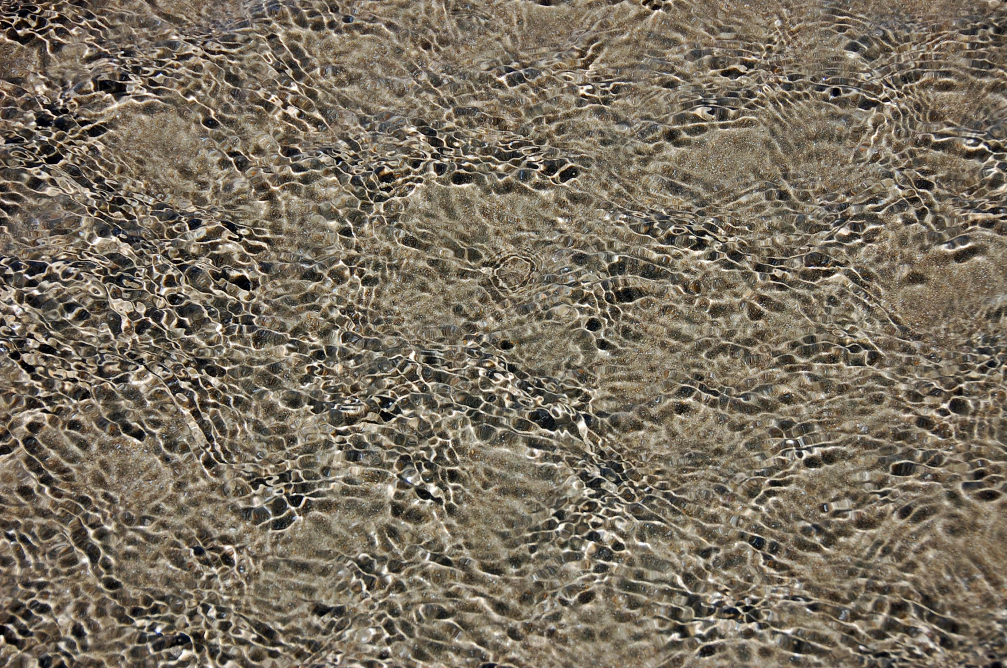 a close up of water and sand on a beach