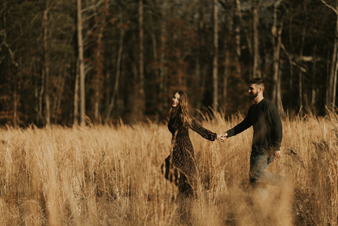 man hand in hand with woman on grass