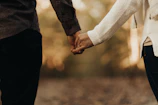 A close-up of a couple holding hands, terracotta hues glowing softly.