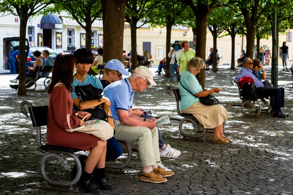 man in blue polo shirt sitting on bench beside man in blue cap