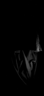 Artistic shot of shadows casting over layered dark clothing pieces