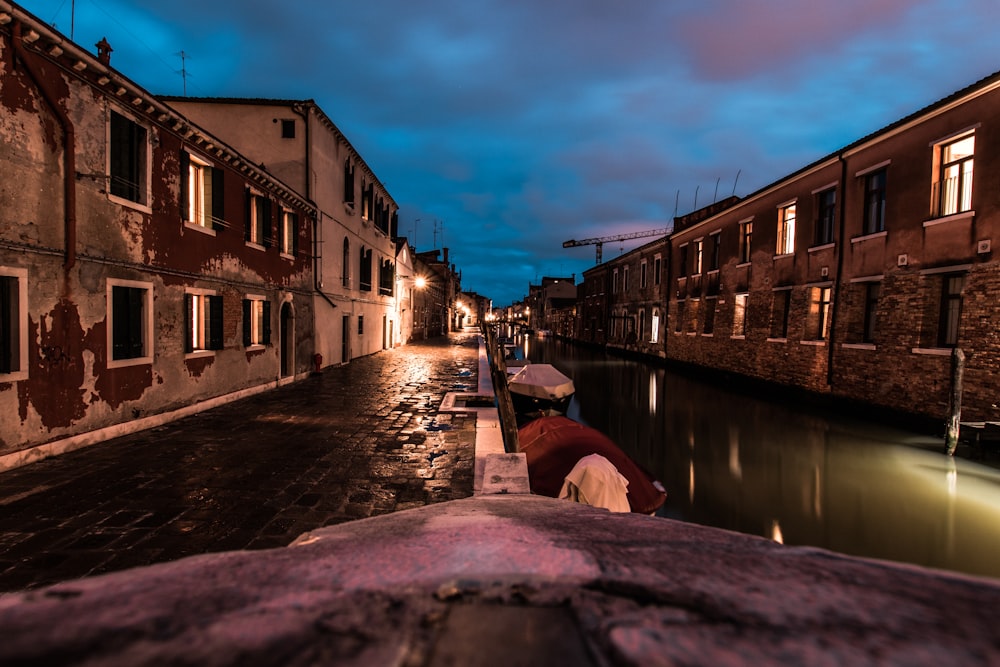 body of water between buildings at night