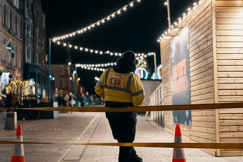 person in yellow jacket leaning on rail